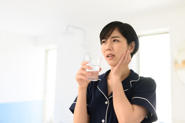 冷たい水で歯がしみる女性｜知覚過敏と虫歯の違いとは？歯がしみる原因と見分け方｜渋谷の歯医者なら渋谷マロン歯科Tokyo