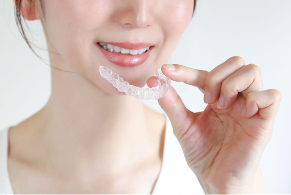 セラミックの白い歯を見せる女性のイメージ画像｜銀歯を白い歯に替える治療法とは？セラミック、コンポジットレジン（CR）など素材ごとの違いを解説｜渋谷の歯医者「渋谷マロン歯科Tokyo」